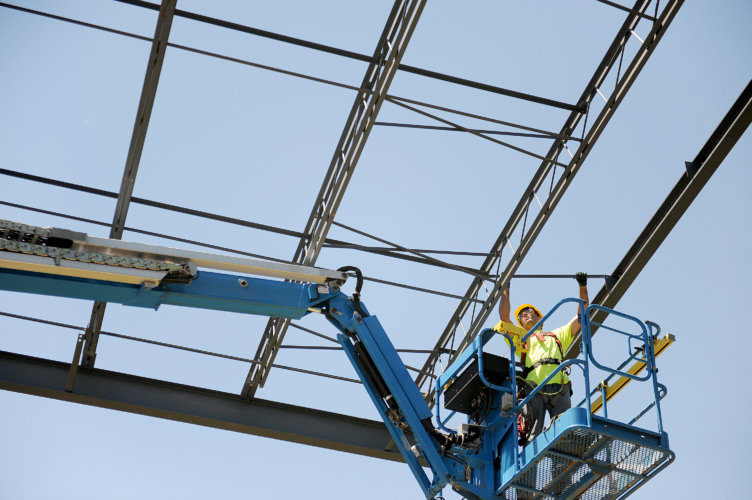 A Zartman Construction worker puts together part of the roof of a new distribution facility.